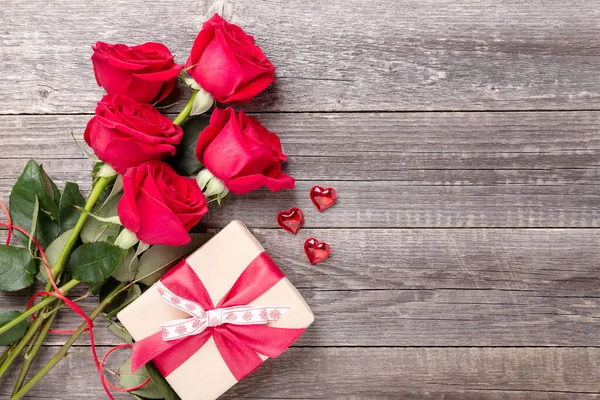 Dia dos Namorados cartão de saudação com vermelho rosa flores buquê e caixa de presente em um vintage em mesa de madeira cinza. Vista superior. Espaço de cópia — Fotografia de Stock