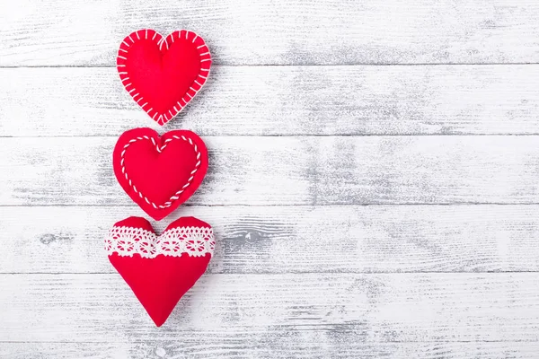Corazones rojos sobre fondo blanco de madera. El concepto de San Valentín. Copia espacio para tu texto — Foto de Stock