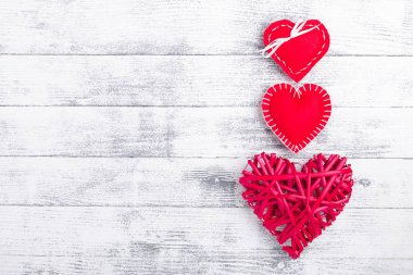 Ahşap beyaz arka planda kırmızı kalpler. Sevgililer Günü konsepti. Metnin için boşluk kopyala