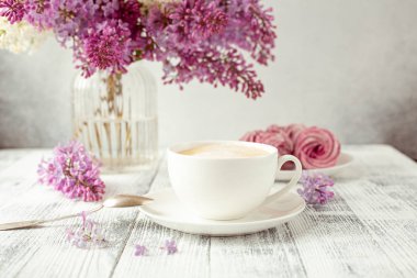 Bir fincan kahve, ev yapımı marşmelov, leylak çiçekleri. Romantik bahar sabahı Seçici odak