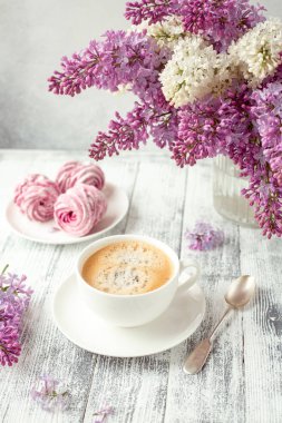 Bir fincan kahve, ev yapımı marşmelov, leylak çiçekleri. Romantik bahar sabahı Seçici odak