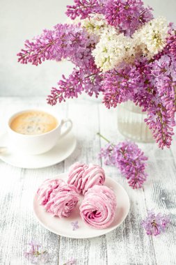 Leylak, kahve ve beyaz seramik tabakta ev yapımı pembe marşmelov. Romantik bir bahar sabahı. Seçici odak