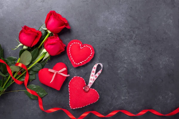 Dia dos Namorados cartão de saudação. Rosas vermelhas e corações têxteis no fundo de pedra. Vista superior — Fotografia de Stock