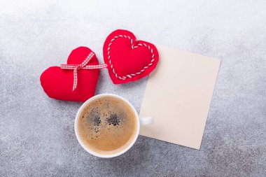 Sevgililer Günü tebrik kartı. Taş zeminde kahve fincanı ve tekstil kalpleri. Üst görünüm