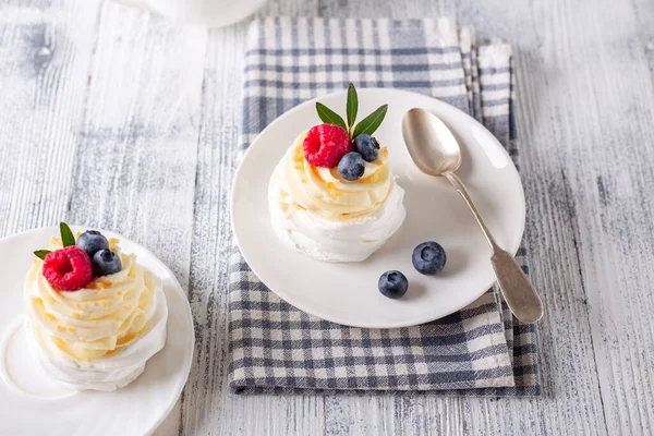 Delicioso pastel Pavlova con crema batida y frambuesa fresca y arándanos. Enfoque selectivo — Foto de Stock