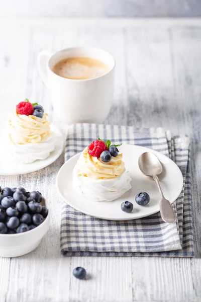 Tort delicios Pavlova cu frisca si fructe de padure proaspete. O ceaşcă albă de cafea. Focalizare selectivă — Fotografie, imagine de stoc