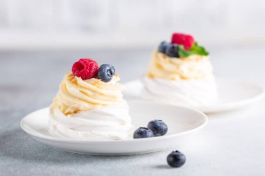 Krem şantili, taze ahududu ve yabanmersinli lezzetli Pavlova pastası. Seçici odak