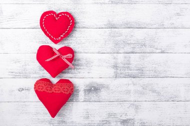 Ahşap beyaz arka planda kırmızı kalpler. Sevgililer Günü konsepti. Metnin için boşluk kopyala