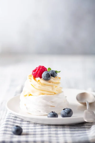 Tort delicios Pavlova cu frisca si fructe de padure proaspete pe placa alba. Stilul scandinav. Focalizare moale — Fotografie, imagine de stoc