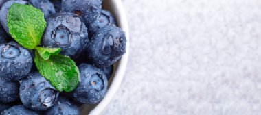 Taze olgun ve sulu yaban mersinli su damlaları. Beyaz kase. Nane yaprağı. Uzayı kopyala Makro Fotoğraf - Resim