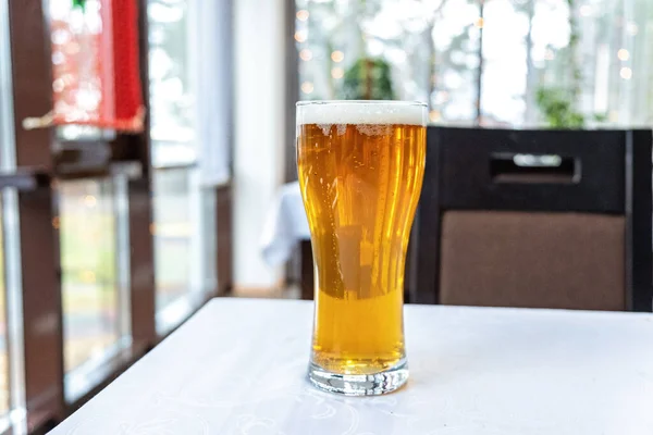 Glass of light beer on a table in a bar - Image