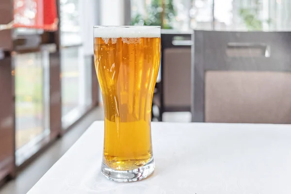 Glass of light beer on a table in a bar - Image