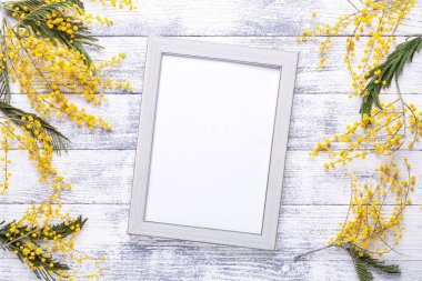 Paskalya dekoru, mimoza çiçekleri ve ahşap masa çerçeveli. Gri çerçeveli bir model. Üst Manzara. Uzayı kopyala - Resim