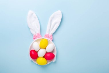Güzel paskalya kompozisyonu. Mavi arka planda çok renkli paskalya yumurtaları ve tavşan kulakları. Üst Manzara. Uzayı kopyala - Resim