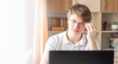 Öğrenci evde dizüstü bilgisayar kullanarak öğreniyor. Ev okulu, çevrimiçi eğitim, ev eğitimi, karantina konsepti - Görüntü