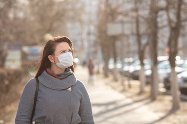 Dışarıda koruyucu tıbbi maske takan bir kadın, yakın çekim. Kişisel bakım kavramını - Görüntü