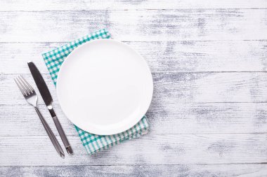 Ahşap arka planda boş beyaz tabak ve çatal bıçak takımı. Uzayı kopyala Üst Görünüm - Resim