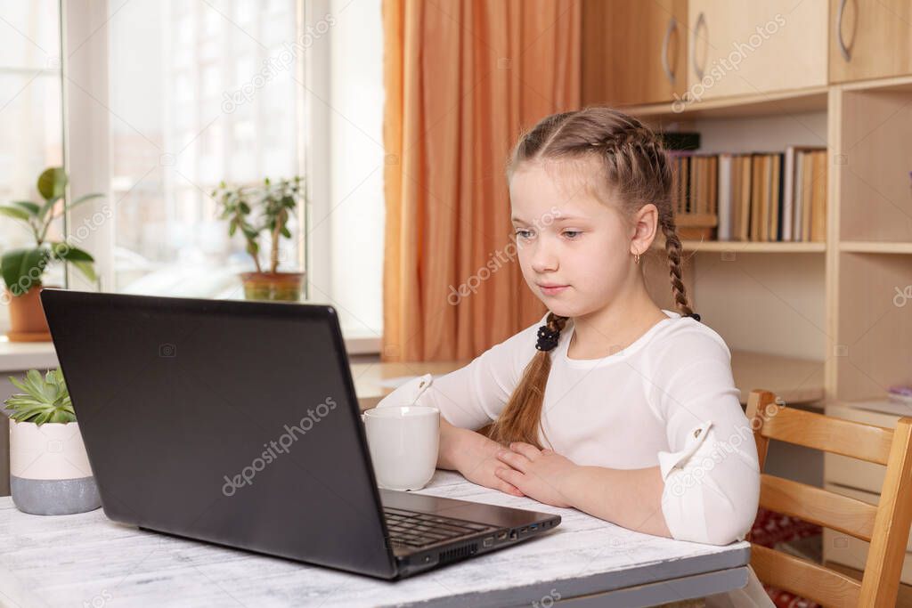 Serious schoolgirl looks at a laptop screen. Distance learning online education, home school, home education, quarantine concept - Image