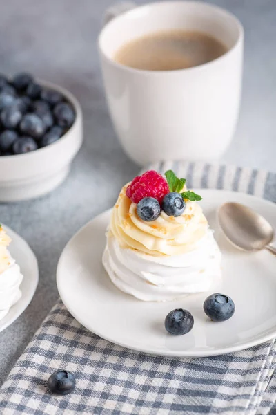 Delicious Pavlova cake with whipped cream and fresh berries. White cup of coffee. Selective focus - Image