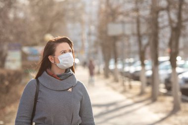 Dışarıda koruyucu tıbbi maske takan bir kadın, yakın çekim. Kişisel bakım kavramını - Görüntü