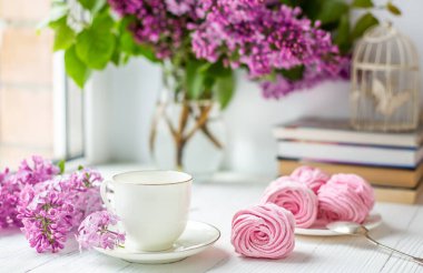 Bir buket leylak, bir fincan kahve, ev yapımı marşmelov. Romantik bir bahar sabahı. Seçici odak