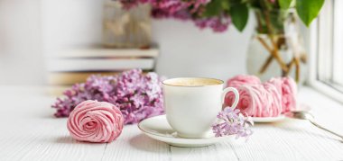 Bir buket leylak, bir fincan kahve, ev yapımı marşmelov ve kitaplar. Romantik bir bahar sabahı. Yatay Sancak Seçici Odaklanma