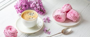 Bir buket leylak, bir fincan kahve, ev yapımı marşmelov ve kitaplar. Romantik bir bahar sabahı. Seçici odak