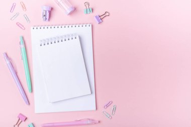 Not defterleri ve pembe arka planda pastel renkli çalışma aksesuarları olan okul arkaplanı metin alanı ile birlikte okula dönüş konsepti