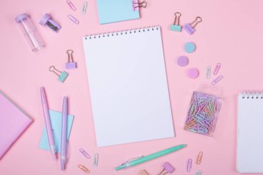 Not defterleri ve pembe arka planda pastel renkli çalışma aksesuarları olan okul arkaplanı metin alanı ile birlikte okula dönüş konsepti