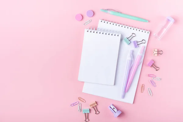 Not defterleri ve pembe arka planda pastel renkli çalışma aksesuarları olan okul arkaplanı metin alanı ile birlikte okula dönüş konsepti