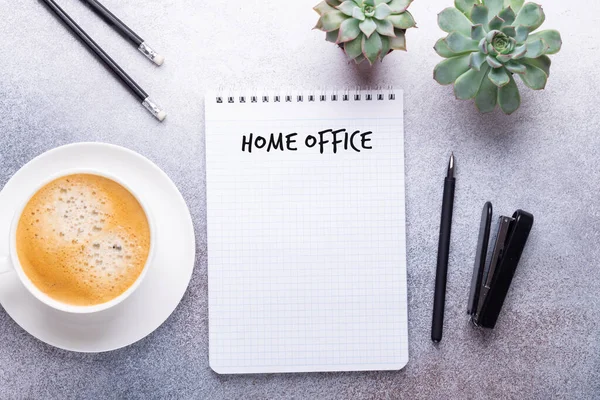 Home office workplace with cup of coffee, succulent, note pad and pen. Working from home concept. Top view - Image