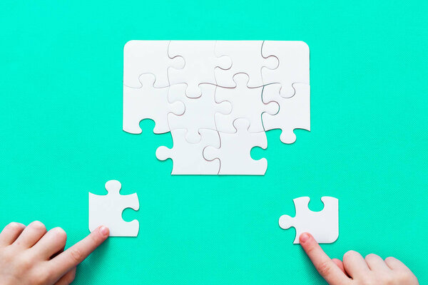 Jigsaw Puzzle with missing piece on mint background Top view People hand