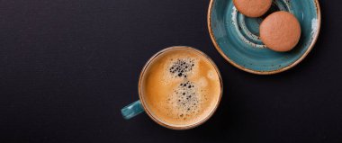 Koyu ahşap masada mavi fincan kahve ve kurabiye. Kahve molası. Üst Manzara. Düz web pankartı