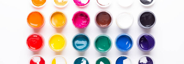 Multicolored gouache on a white background Isolated Paints in containers Top view Copy space Banner Horizontal