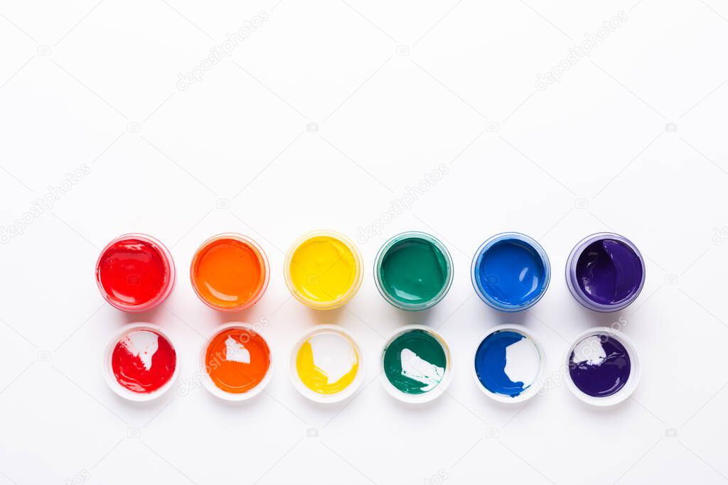 Multicolored gouache on a white background Isolated Paints in containers Top view Copy space