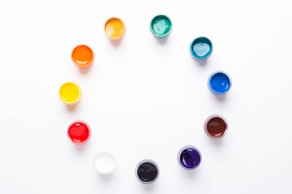 Multicolored gouache on a white background Circle shape Isolated Paints in containers Top view Copy space