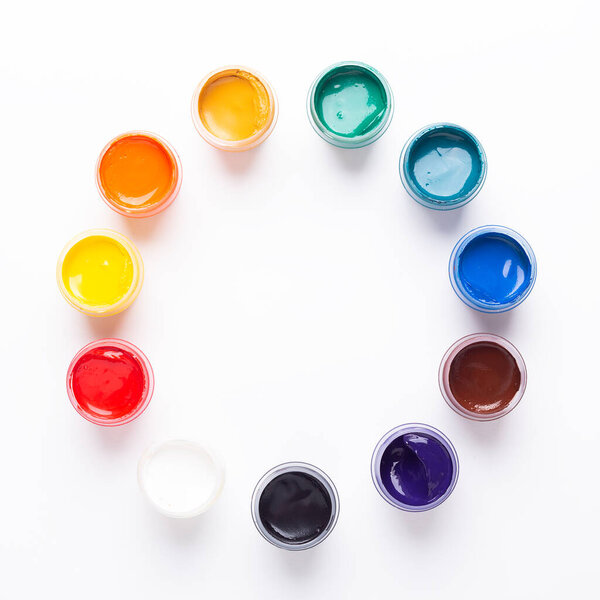 Multicolored gouache on a white background Circle shape Isolated Paints in containers Top view Copy space