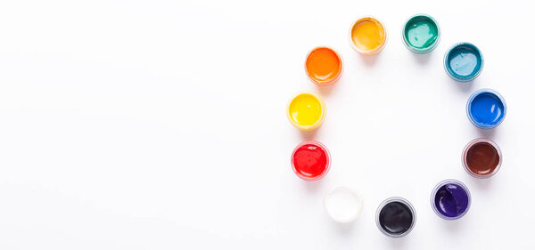 Multicolored gouache on a white background Circle shape Isolated Paints in containers Top view Copy space Banner Horizontal