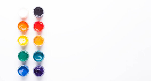 Containers with paints on a white background Multicolored gouache Isolated Top view Copy space Banner Horizontal