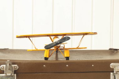 Oyuncak sarı metal uçak Eski eski eski bavullar Beyaz ahşap arka plan Vintage renkli kopyalama alanı