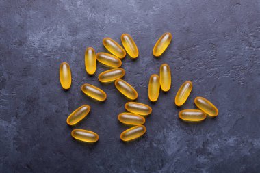 Omega 3 kapsülleri karanlık taş arka planda Üst Bakış Sağlık Konseptini kapat