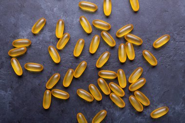 Omega 3 kapsülleri karanlık taş arka planda Üst Bakış Sağlık Konseptini kapat