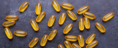Omega 3 kapsülleri karanlık taş arka planda Üst Bakış Sağlık Konseptini kapatın