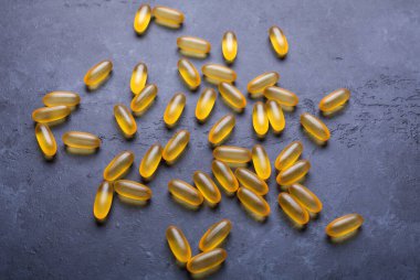 Omega 3 kapsülleri karanlık taş arka planda Üst Bakış Sağlık Konseptini kapat
