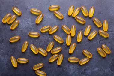 Omega 3 kapsülleri karanlık taş arka planda Üst Bakış Sağlık Konseptini kapat