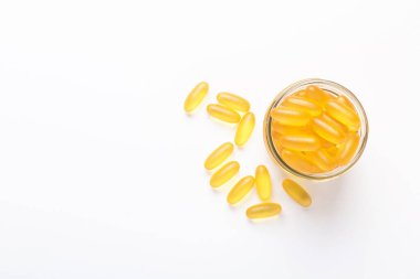 Beyaz zemin üzerinde cam kavanozda Omega 3 kapsülleri Balık yağı Sarı softgeller D vitamini, E vitamini sağlık hizmetlerinin ilave kavramı Üst görünüm, düz konum, kopyalama alanı