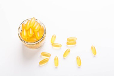 Beyaz zemin üzerinde cam kavanozda Omega 3 kapsülleri Balık yağı Sarı softgeller D, E vitamini, sağlık hizmetlerinin bir ilave kavramı