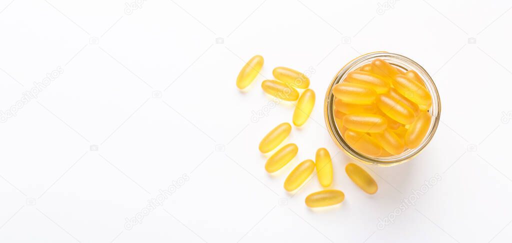 Omega 3 capsules in glass jar on white background Fish oil Yellow softgels Vitamin D, E, A supplement Banner Concept of healthcare Copy space