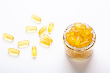 Beyaz zemin üzerinde cam kavanozda Omega 3 kapsülleri Balık yağı Sarı softgeller D, E vitamini, sağlık hizmetlerinin bir ilave kavramı
