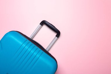 Pastel pembe arka planda mavi bavul Yaz tatili, tatil, seyahat konsepti En az kopyalama alanı
